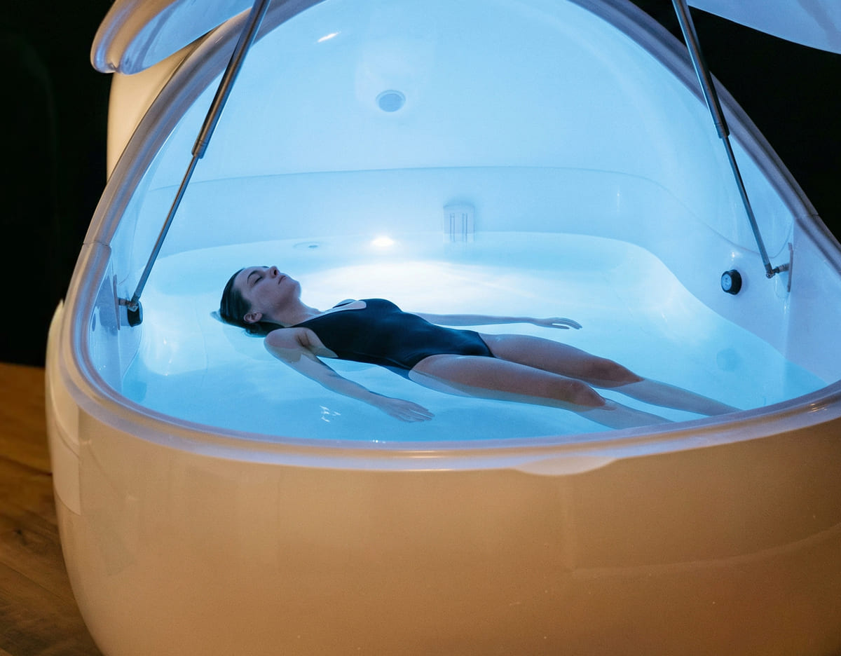 Femme flottant dans une cabine de flottaison.